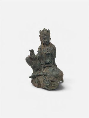 statue of a woman sitting on a rock holding a cat