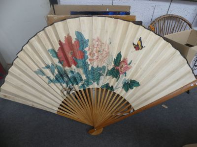 a fan with flowers and butterflies on it in a room