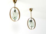 une paire de boucles d'oreilles en verre vert et en laiton suspendues au plafond