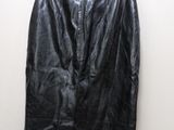 a black leather skirt hanging on a hanger against a white wall
