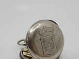 an image of a silver pocket watch sitting on top of a stack of coins