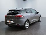 the rear end of a grey car with its trunk open