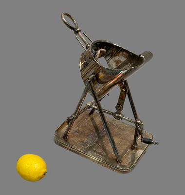 a silver plate with a lemon on it and a silver plate with a knife on it