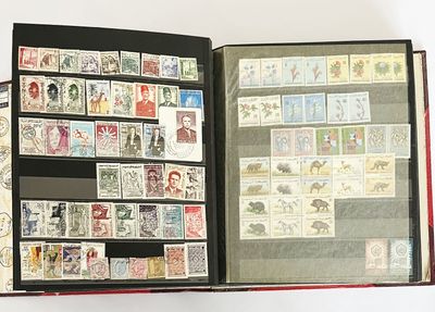 un livre ouvert, orné de timbres, posé sur une surface blanche