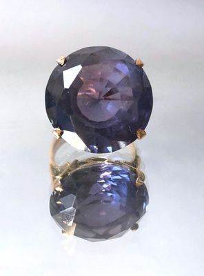 an image of a ring with a purple stone on top of it
