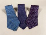 three ties are lined up in a row on a white surface