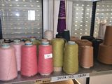 many spools of thread on a shelf in a room