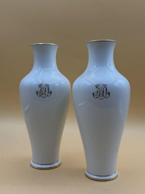 deux vases blancs posés l'un à côté de l'autre sur une table