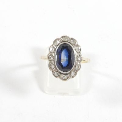 gros plan d'une bague avec une pierre bleue entourée de diamants