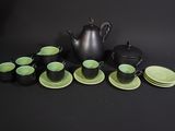 many cups and saucers sitting on a black table