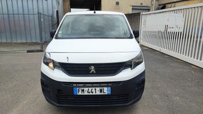 la petite camionnette blanche est garée devant un bâtiment