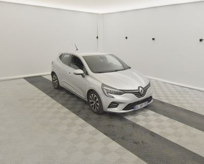 Une voiture blanche est garée dans un garage dont le sol est en damier.