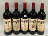 six bottles of wine are lined up on a white surface