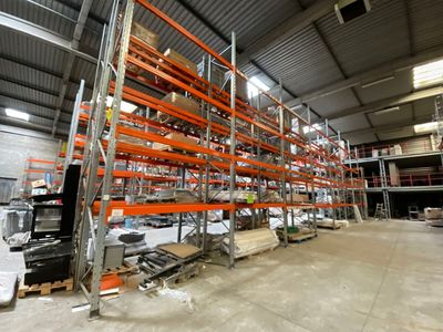 un grand entrepôt rempli d'étagères et de palettes