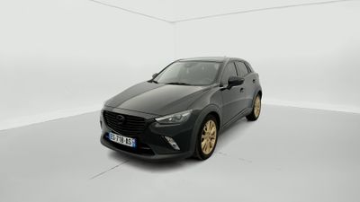 Une voiture grise est garée dans une pièce blanche au sol blanc.