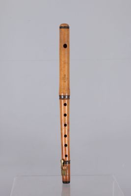 a close up of a wooden flute on a clear surface