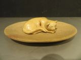 a yellow plate with a cat on it on a table