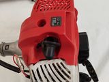 a red and black blower sitting on a white sheet