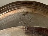 a close up of a silver plate with a crown on it