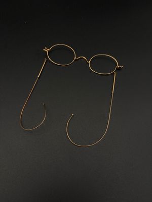 une paire de lunettes et un crochet sur une surface noire