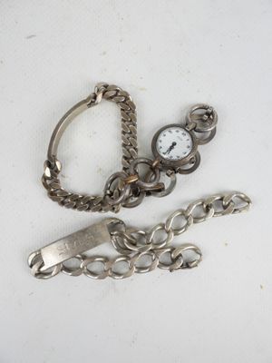 a silver watch and a chain on a white surface