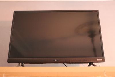 a flat screen tv sitting on top of a shelf