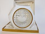 une horloge blanche et dorée sur laquelle figure l'image d'un homme