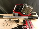 un aspirateur rouge et noir posé sur une table en bois
