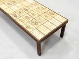 a coffee table with a tile top and wooden legs