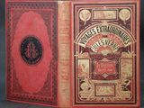 an old book with a red cover sitting on a table
