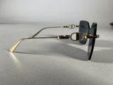 sunglasses on a white surface with a black lens and a gold chain