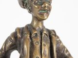 bronze figurine of a woman with a hat and jacket