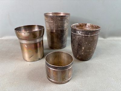 trois tasses en argent posées l'une à côté de l'autre sur une table
