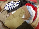 a pile of clothes in a suitcase on the floor