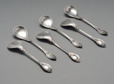 six cuillères en argent ornées de motifs élaborés sur un fond gris