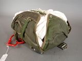 a green duffel bag with a pair of scissors in it