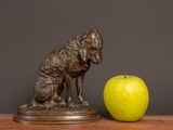 a statue of a dog and an apple on a table