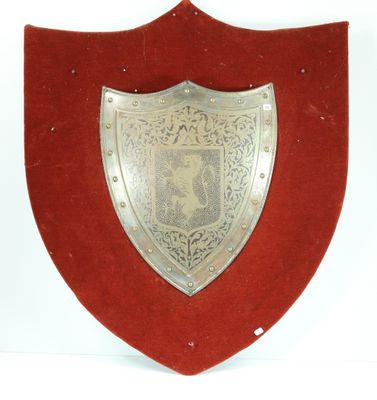 silver plated shield mounted on red velvet with a horse on it
