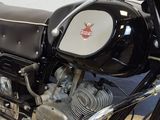 a black motorcycle parked in a garage with a white wall in the background