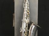 an old silver saxophone with a silver case on a black background