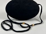 a black purse with a gold clasp on a white background