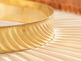 a gold bracelet sitting on top of a wooden table