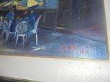 un tableau représentant des personnes assises à une table sous des parasols