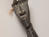 une sculpture en bois représentant un homme coiffé d'un chapeau