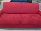 deux canapés, un rouge et un bleu, dans un salon où se trouvent d'autres meubles