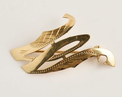 trois barrettes de couleur dorée posées sur une surface blanche