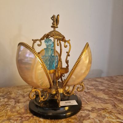 une image représentant un coquillage doré et bleu sur lequel est perché un oiseau
