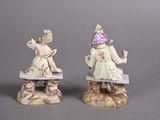 two figurines of children sitting on a bench