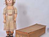 a doll that is standing next to a box
