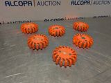 several orange plastic balls are arranged on a metal surface